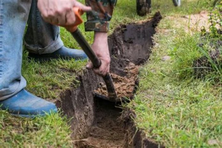 How do you dig a trench by hand?