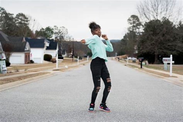 Jalaiah Harmon on the streets of her hometown posing a move from her Renegade Dance.