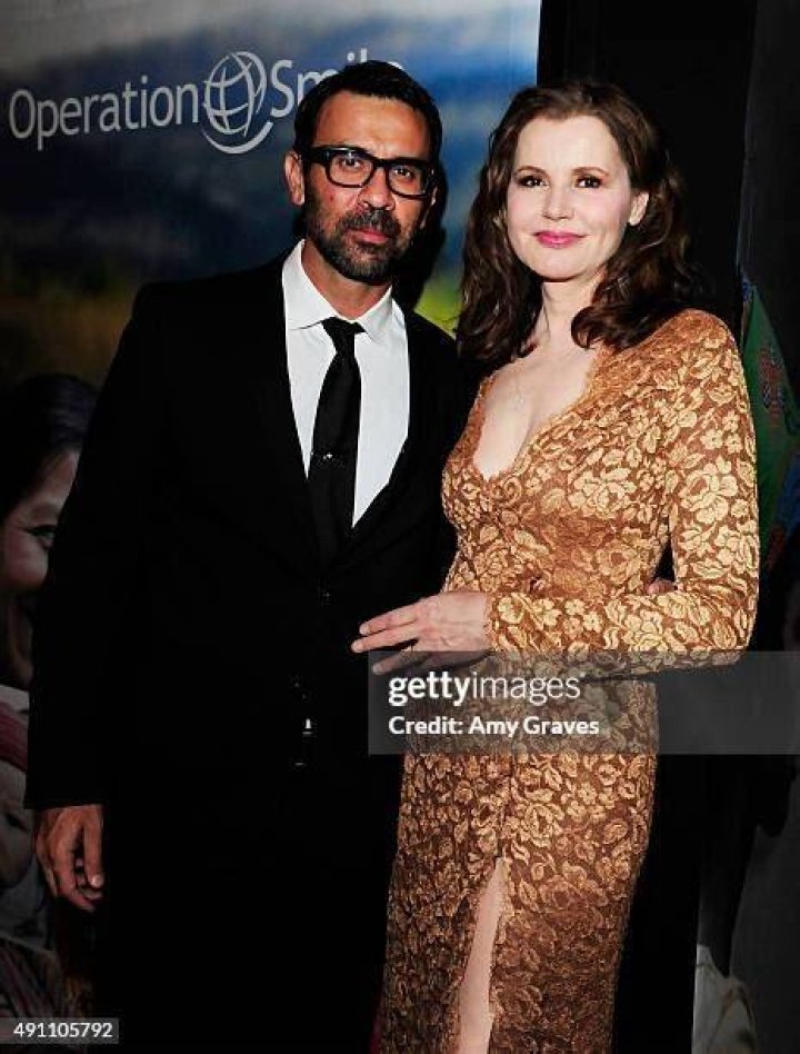 Reza Jarrahy is on a black suit whereas, Geena Davis is wearing a white dress.