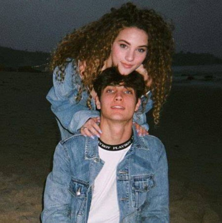 Sofie Dossi and her boyfriend Dom Brack kissing in front of the Disneyland Palace during an evening date.