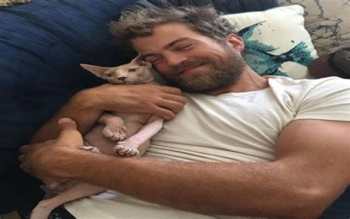 Sterling Pierce Taylor hugging a dog in a white t-shirt.